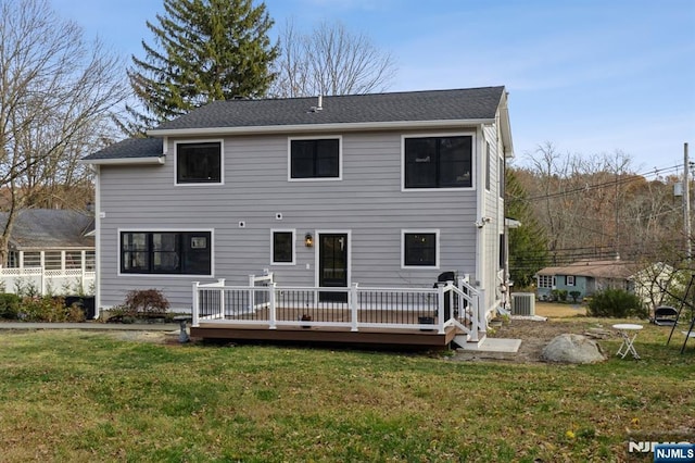 rear view of property featuring cooling unit, a yard, and a wooden deck