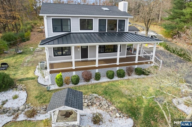 view of front of house with central AC unit, a chimney, roof with shingles, covered porch, and a standing seam roof