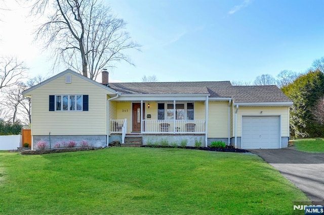 ranch-style house with a chimney, covered porch, a front yard, a garage, and driveway