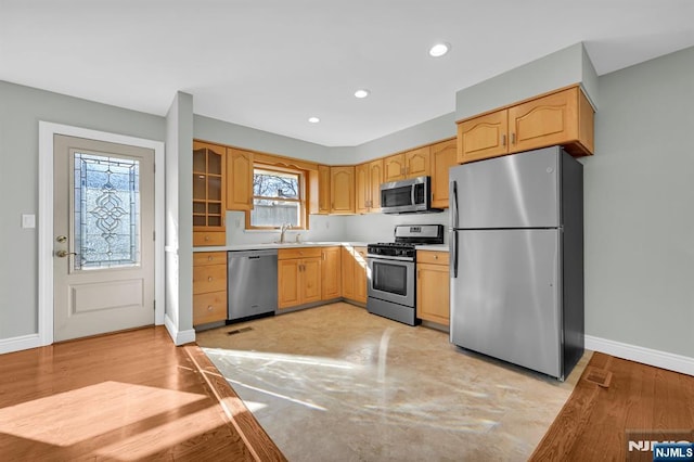 kitchen with light wood-style flooring, recessed lighting, stainless steel appliances, baseboards, and light countertops