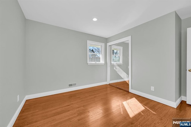 unfurnished bedroom featuring baseboards, visible vents, wood finished floors, and recessed lighting