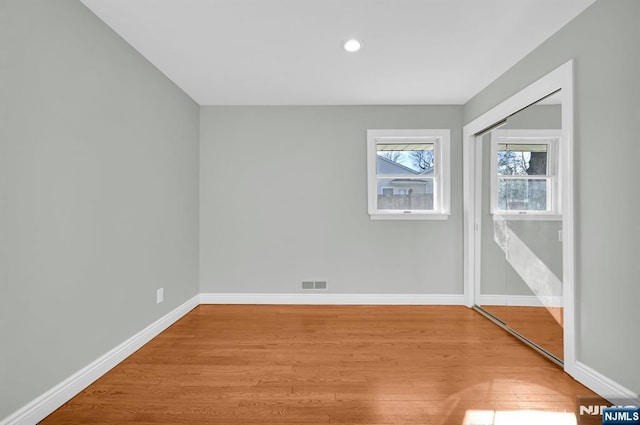 unfurnished room with recessed lighting, visible vents, baseboards, and wood finished floors