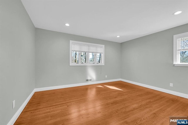 spare room featuring visible vents, baseboards, wood finished floors, and recessed lighting