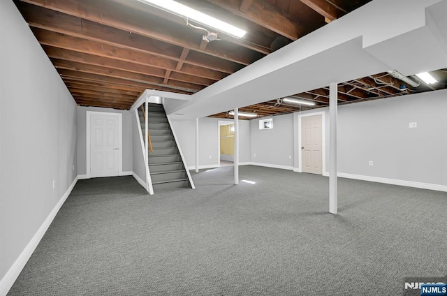 finished basement with carpet flooring, stairway, and baseboards