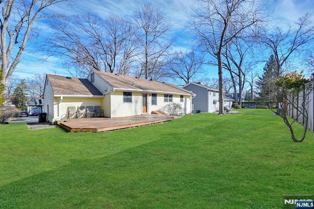 back of house with a lawn, a wooden deck, and fence