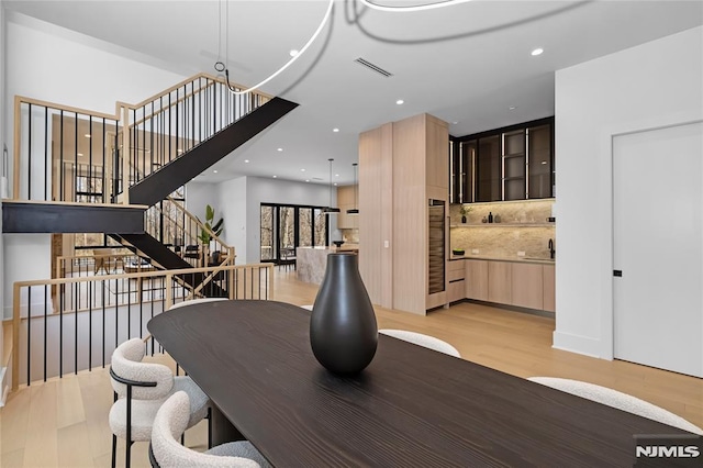 dining area featuring stairs, light wood finished floors, visible vents, and recessed lighting