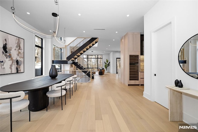 dining area with recessed lighting, light wood-style flooring, and stairs