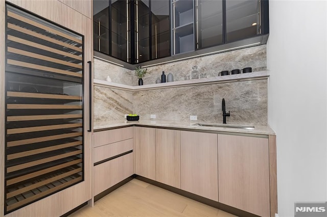 kitchen featuring tasteful backsplash, beverage cooler, light countertops, and light brown cabinetry