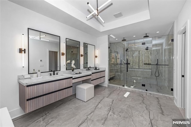 full bath featuring marble finish floor, a tray ceiling, a stall shower, and vanity