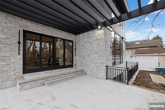 property entrance with a patio area and fence