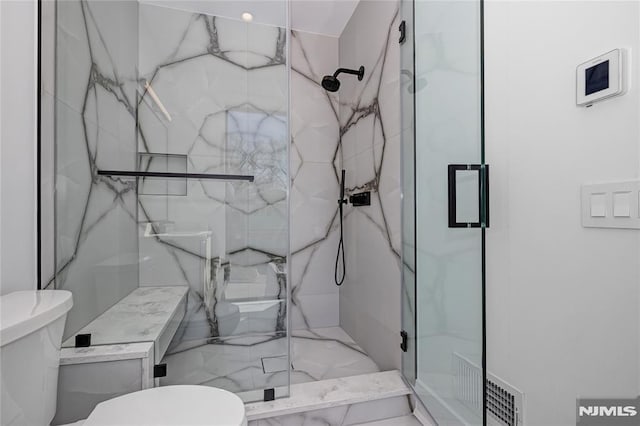 full bath featuring toilet, a marble finish shower, and visible vents