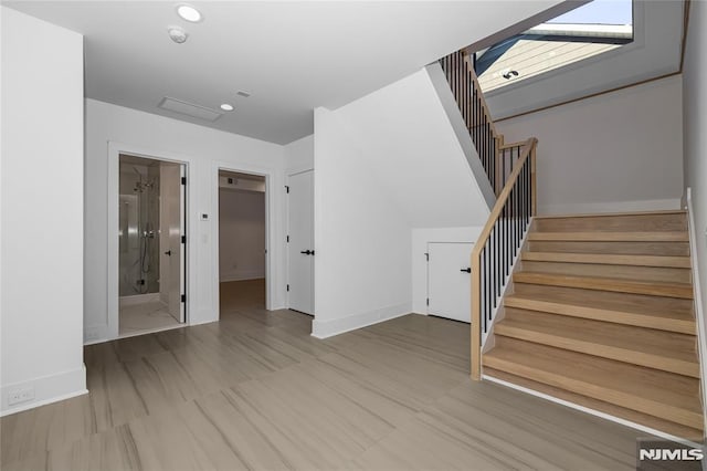 interior space featuring recessed lighting, stairway, and baseboards