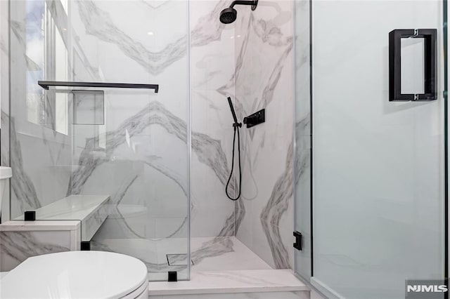 full bath with a marble finish shower and toilet