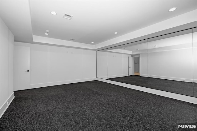 unfurnished room with recessed lighting, a raised ceiling, visible vents, and baseboards