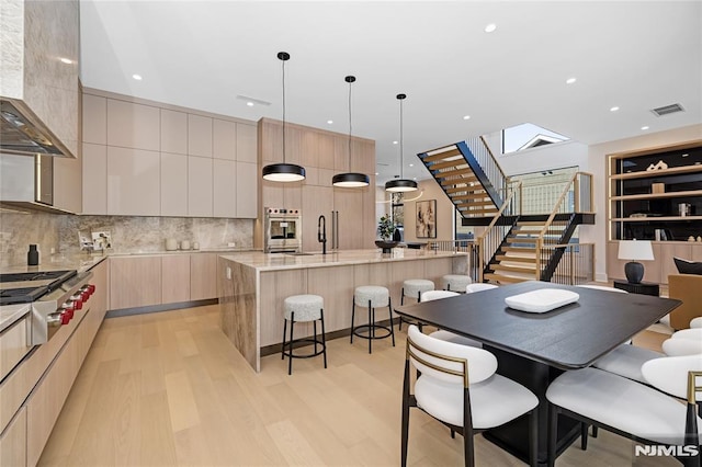 dining space featuring light wood-style floors, stairs, visible vents, and recessed lighting