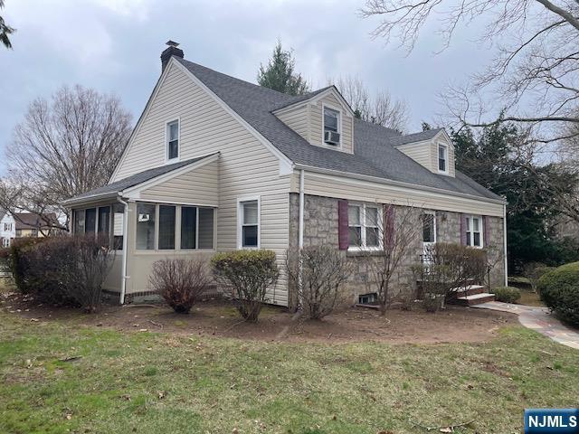 view of front facade with a chimney and a front lawn