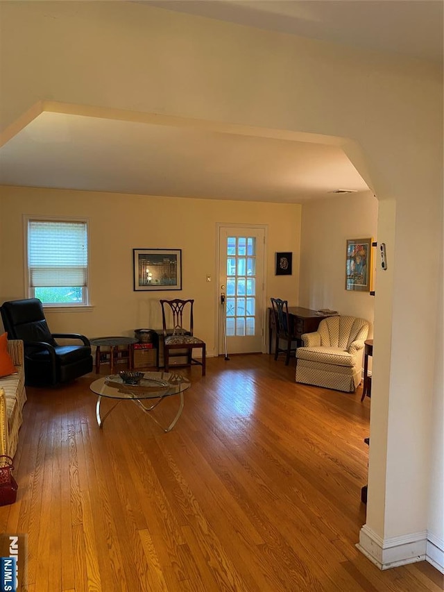 living room with wood finished floors and arched walkways