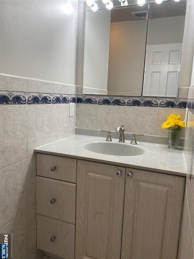 bathroom with vanity and tile walls