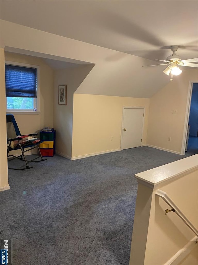 bonus room featuring dark colored carpet, a ceiling fan, baseboards, and lofted ceiling