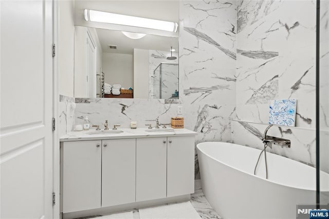 bathroom with double vanity, a soaking tub, a sink, and a marble finish shower