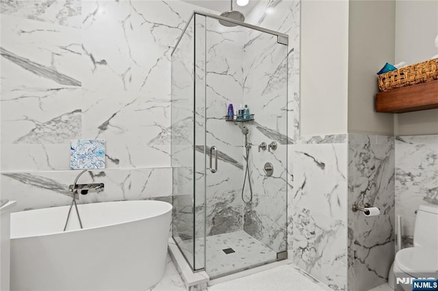 full bathroom with toilet, tile walls, a freestanding bath, marble finish floor, and a marble finish shower