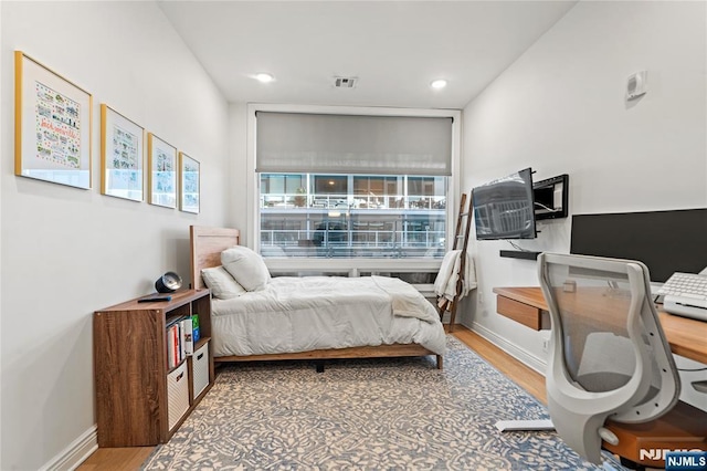 bedroom with baseboards, visible vents, wood finished floors, and recessed lighting