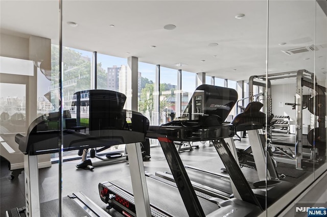 gym with a wall of windows, visible vents, and a city view