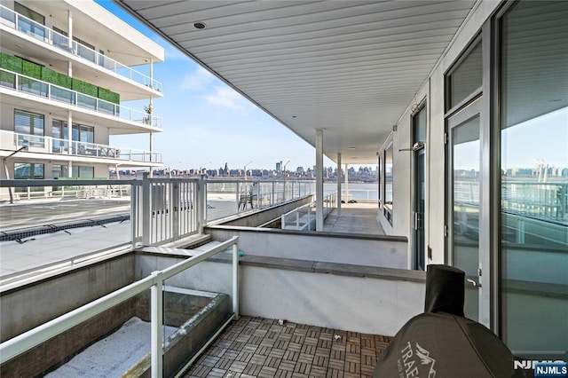 balcony featuring a water view and a city view