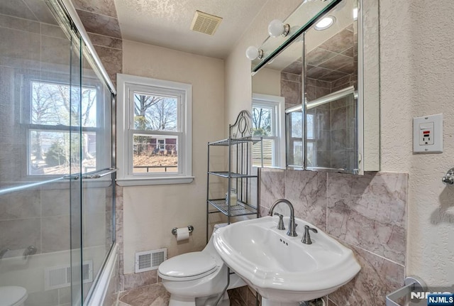 bathroom featuring toilet, visible vents, and a sink