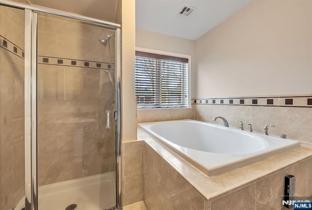 bathroom featuring visible vents, a stall shower, and a bath