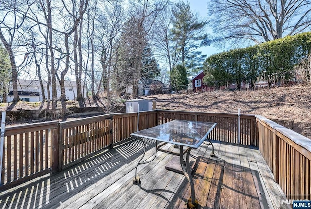 wooden deck with outdoor dining space, an outbuilding, and a storage shed