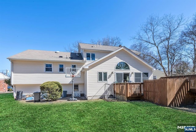 back of house with a lawn, a deck, and fence