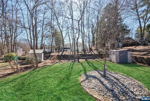 view of yard featuring an outbuilding, a storage shed, and fence