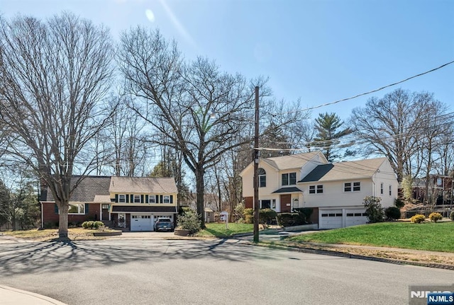 view of front facade with a garage, driveway, and a front yard