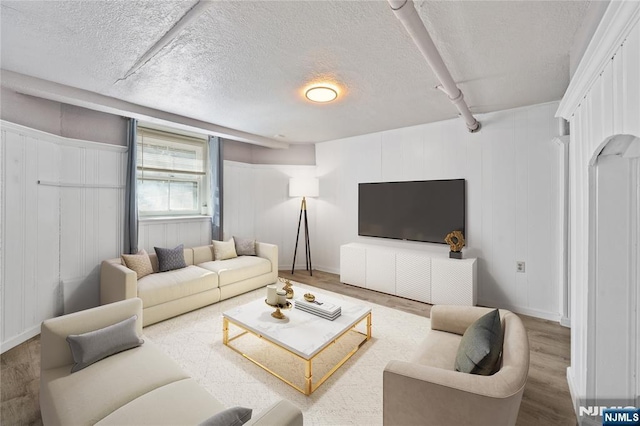 living area with a textured ceiling and wood finished floors