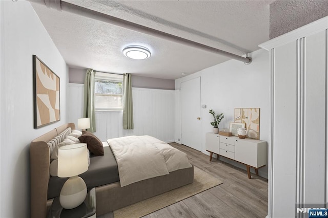 bedroom featuring a textured ceiling and wood finished floors