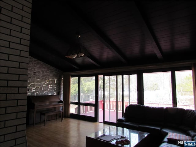 living room with lofted ceiling with beams and wood finished floors