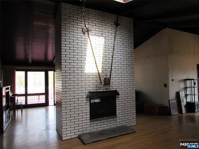 living area featuring vaulted ceiling and wood finished floors