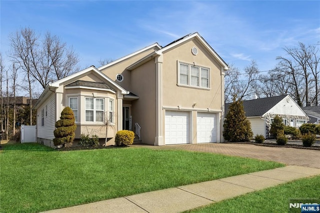 traditional home featuring a garage, decorative driveway, a front yard, and stucco siding