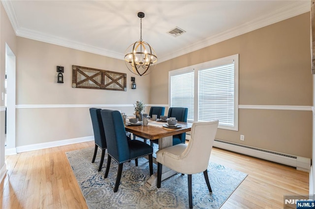 dining area with visible vents, light wood-style flooring, an inviting chandelier, crown molding, and a baseboard heating unit