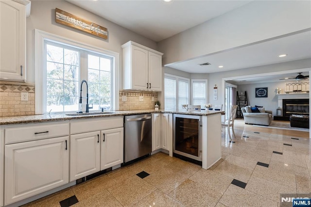 kitchen featuring wine cooler, recessed lighting, a sink, decorative backsplash, and dishwasher