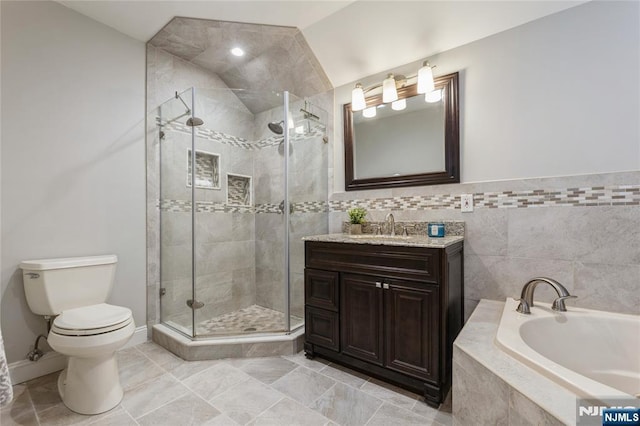 bathroom with a garden tub, a shower stall, toilet, and vanity