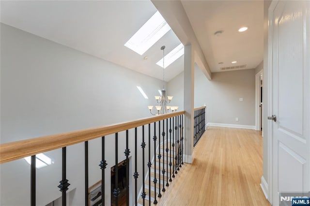 hallway with recessed lighting, visible vents, a chandelier, light wood-type flooring, and baseboards