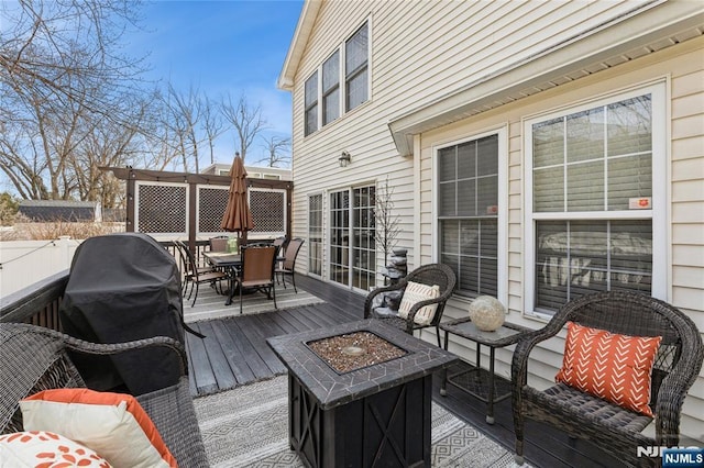 wooden terrace featuring outdoor dining space and an outdoor fire pit