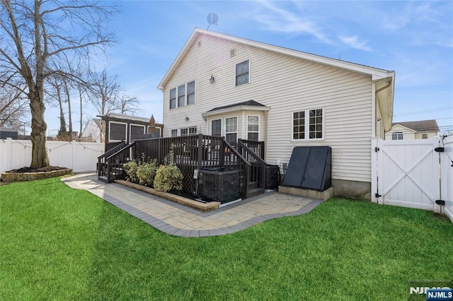 back of property with a yard, a patio, a gate, a fenced backyard, and a wooden deck