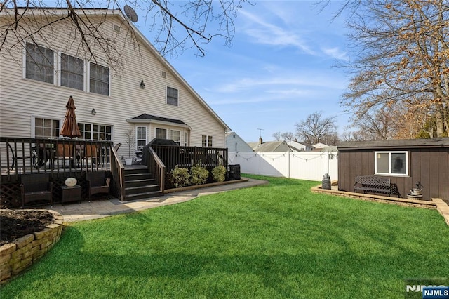 view of yard featuring a deck, a patio area, and fence