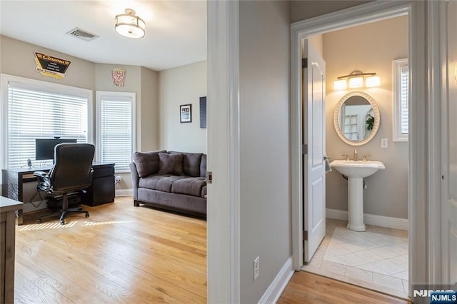 office space featuring visible vents, baseboards, and wood finished floors