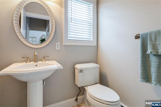 bathroom featuring a sink, toilet, and baseboards