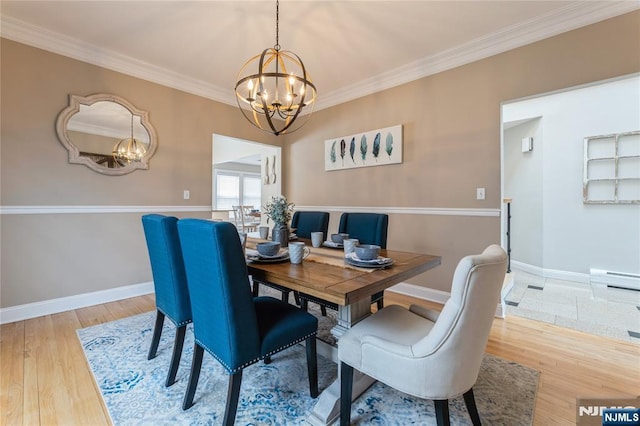 dining room with crown molding, baseboards, a notable chandelier, and wood finished floors