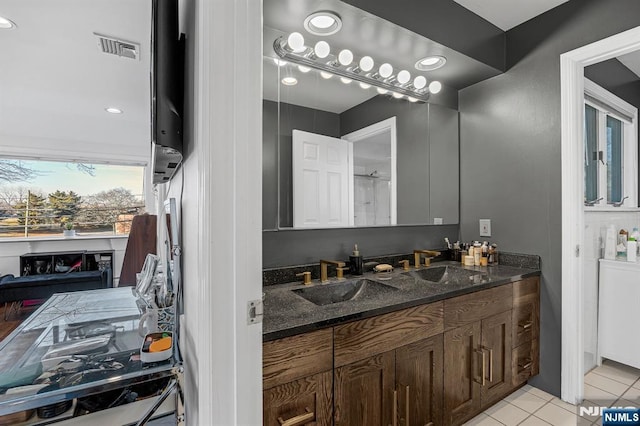 full bathroom featuring double vanity, visible vents, a sink, and tile patterned floors